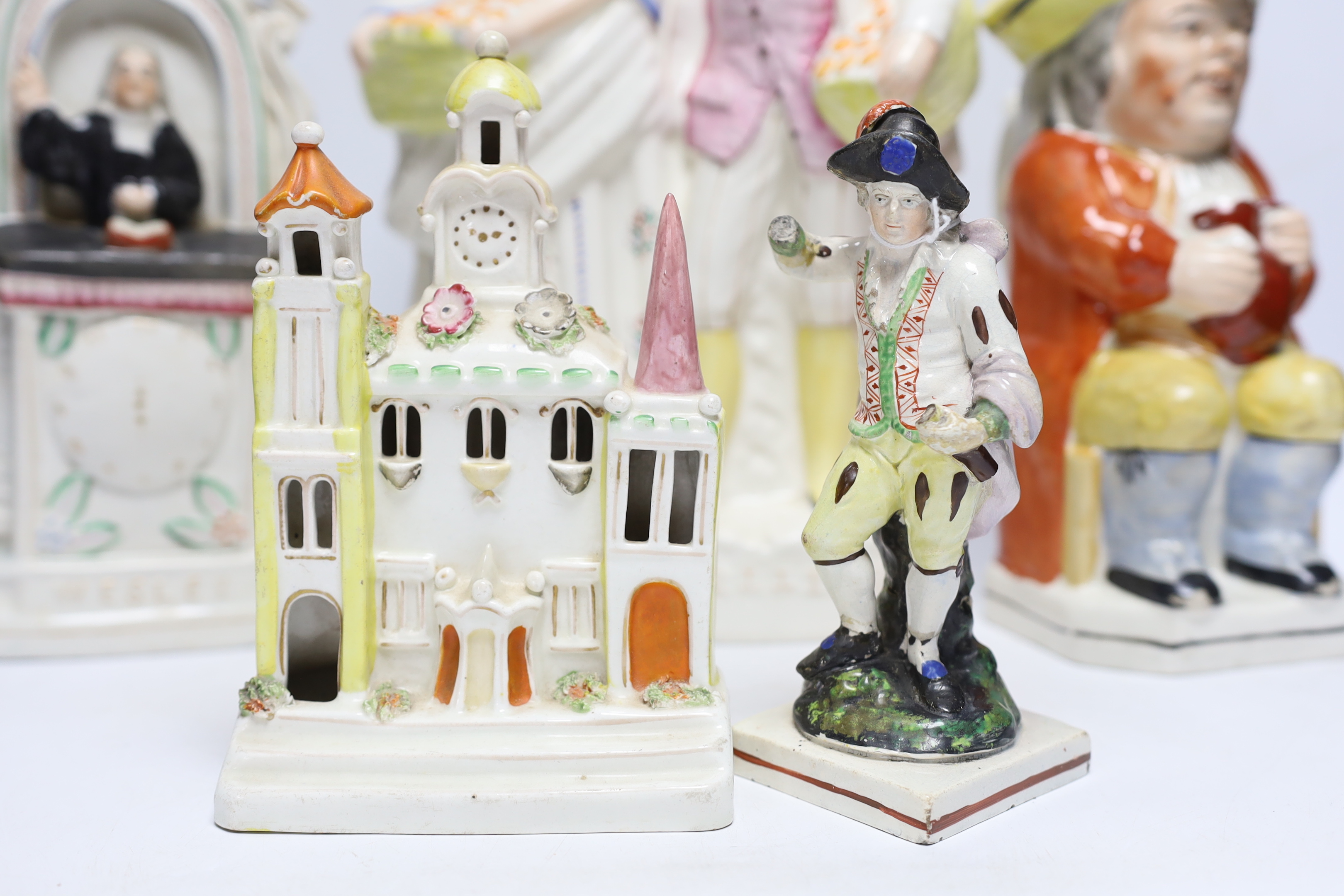 Seven 19th century Staffordshire figure groups including Orange Sellers and Wesley, together with a Toby jug, 35cm high